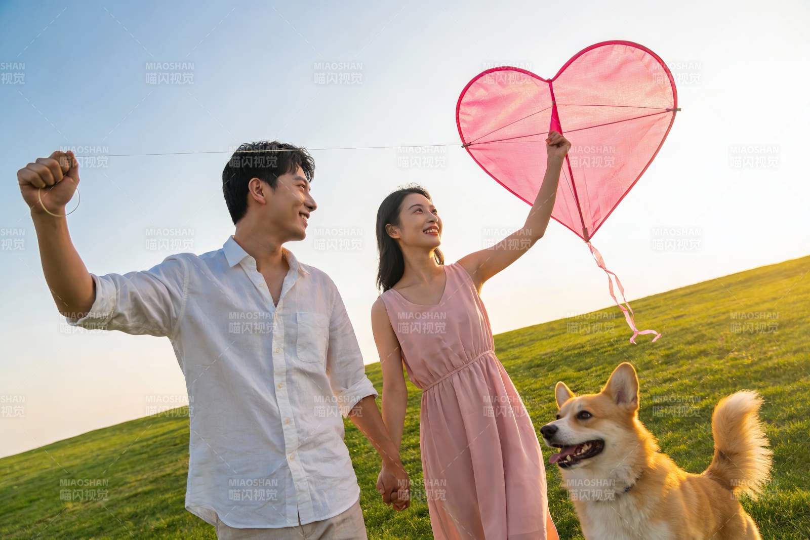 情侣放飞爱心风筝与宠物狗图片