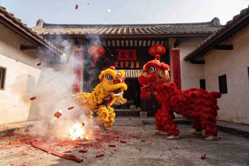 传统舞狮表演燃放鞭炮图片