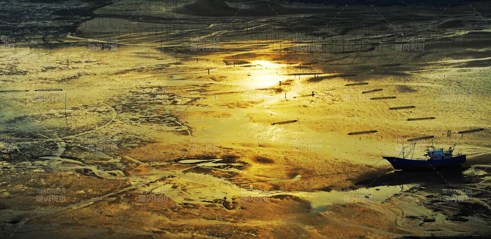 夕阳下的滩涂渔船图片