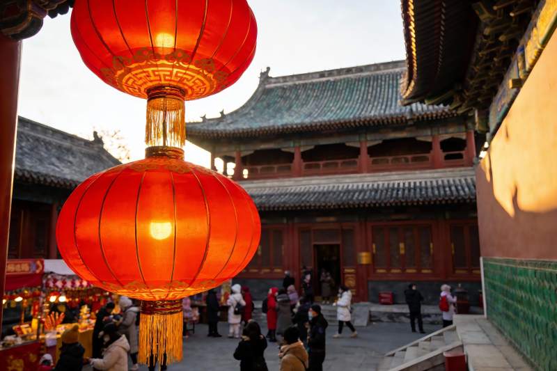 古建筑前红灯笼高挂人群熙攘图片