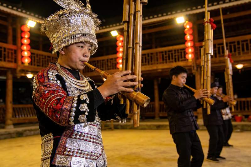 民族服饰乐手演奏竹管乐器图片