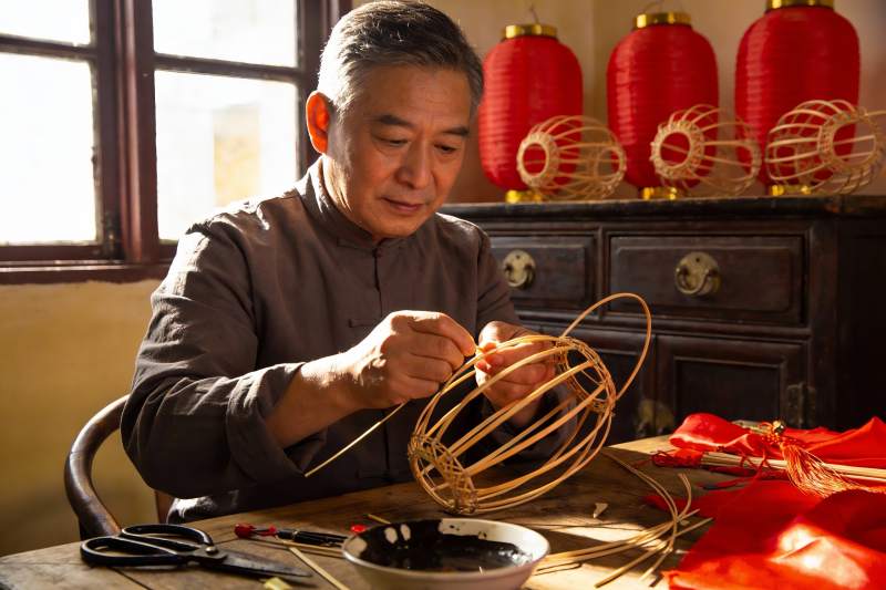 老人制作传统灯笼的手工艺场景图片