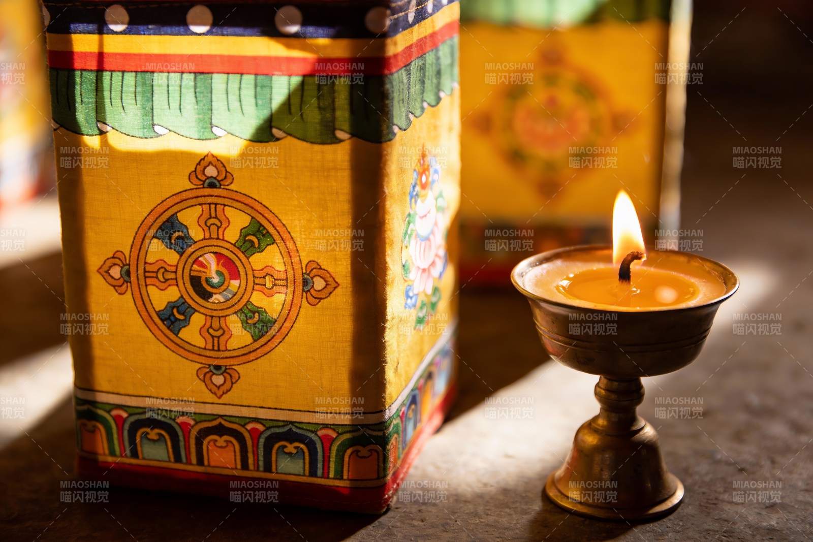 藏式转经筒与烛光静谧场景图片