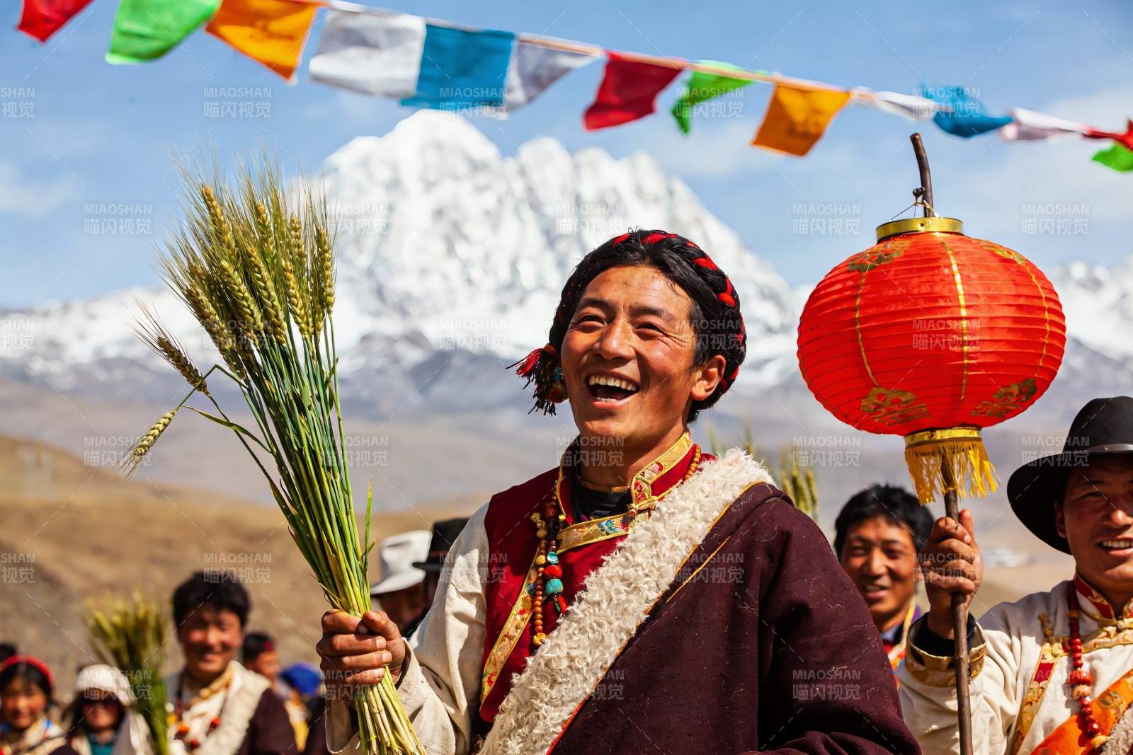 雪山前身着民族服饰的人群欢庆图片