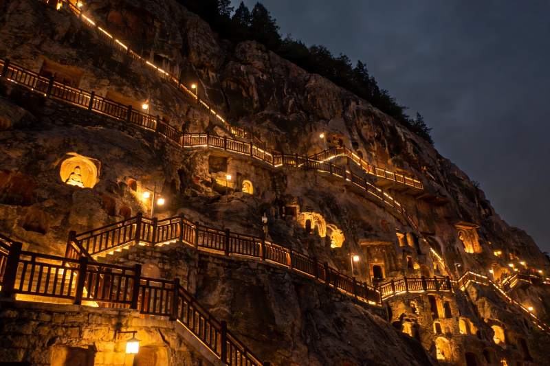 夜幕下的山崖佛龛与栈道图片