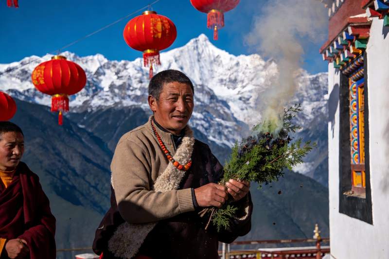 雪山前僧侣手持香草仪式图片