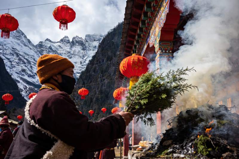 雪山寺庙前僧人焚香祈福图片