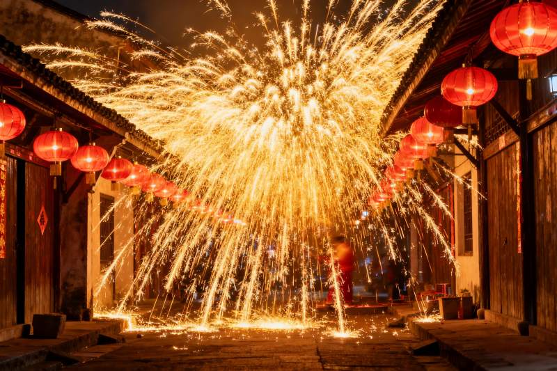 古巷夜空烟花绽放灯笼高挂图片