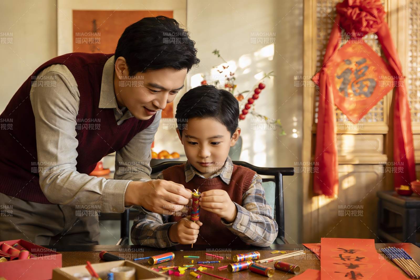 父子室内制作鞭炮准备节日图片