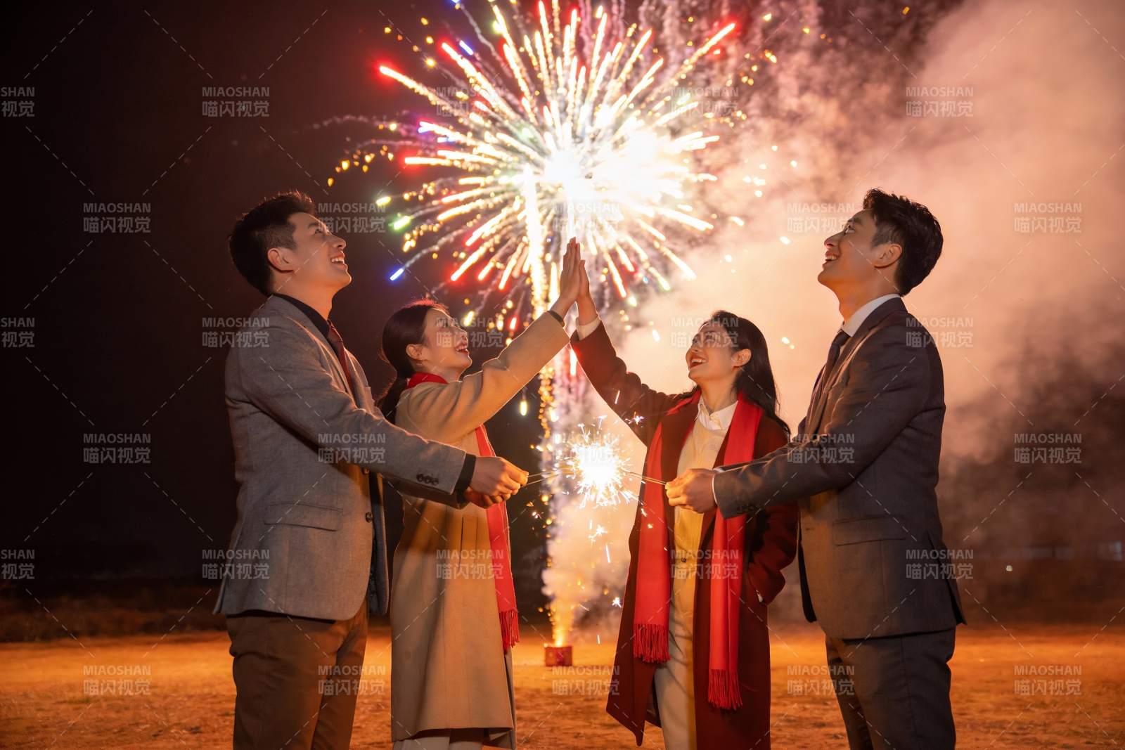 四人夜空烟花下击掌庆祝图片