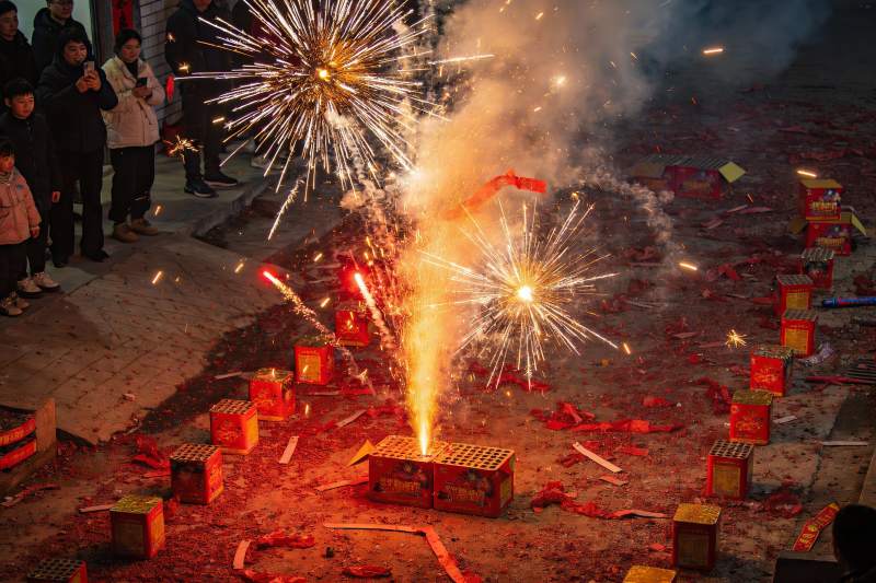 夜空中绽放的烟花与围观人群图片